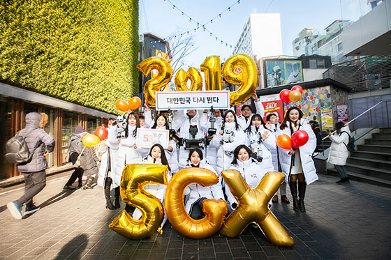 SK텔레콤 신입사원들과 대한민국 대표 로봇 ‘똘망’이 서울 명동에서 기해년 희망찬 새해를 기원하는 ‘대한민국 다시 뛴다’ 메시지를 들어 보이고 있는 모습