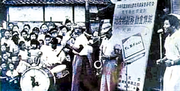 동네 공터를 찾아와 북 치고 노래하며 주민들을 모으고 있는 옛 약장수1960년대의 풍경으로 추정 (조선닷컴)